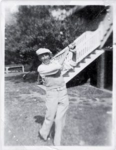 Photo shows Alexander swinging golf club.