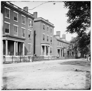 South side of Franklin Street, two blocks west of Capitol Square, 1865, showing typical antebellum houses. The 1844 Norman Stewart House, second from left, rented by Gen. Robert E. Lee for his family during the war, is the only surviving dwelling on the block today. Courtesy Library of Congress.